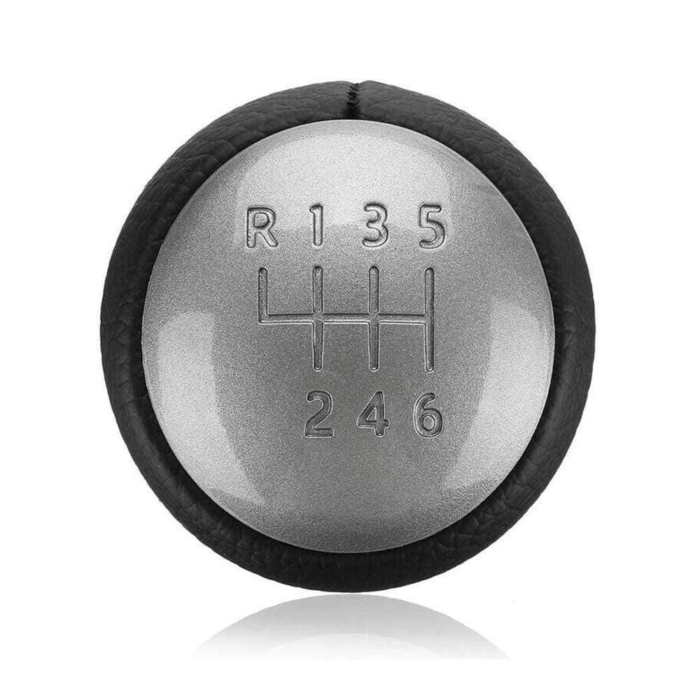 Fekete színű, bőrözött 6 sebességes Nissan váltógomb. Ezüst színű számlappal.