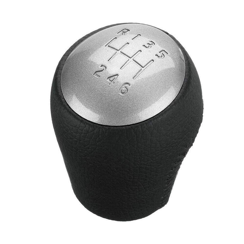 Fekete színű, bőrözött 6 sebességes Nissan váltógomb. Ezüst színű számlappal.